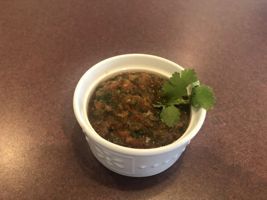 A small bowl of salsa on a table.
