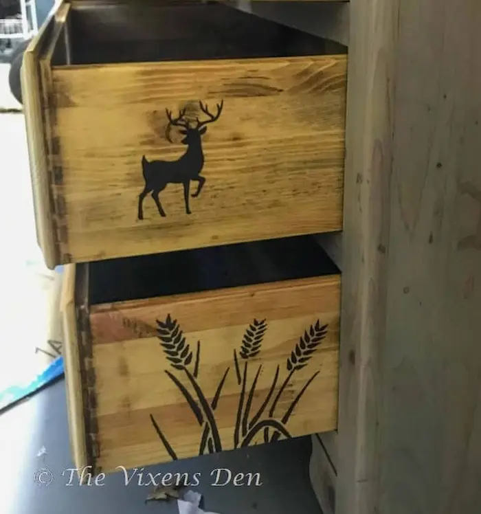 Drawers with deer and wheat stenciled on them.
