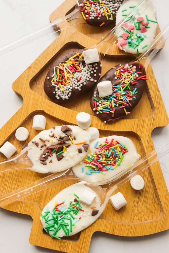 A tray of chocolate covered cookies with sprinkles and marshmallows.