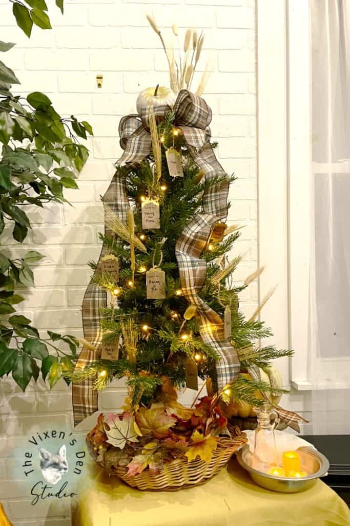 A christmas tree decorated with leaves and a bow.