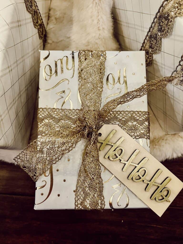 A gift wrapped in gold and white with a tag on it.