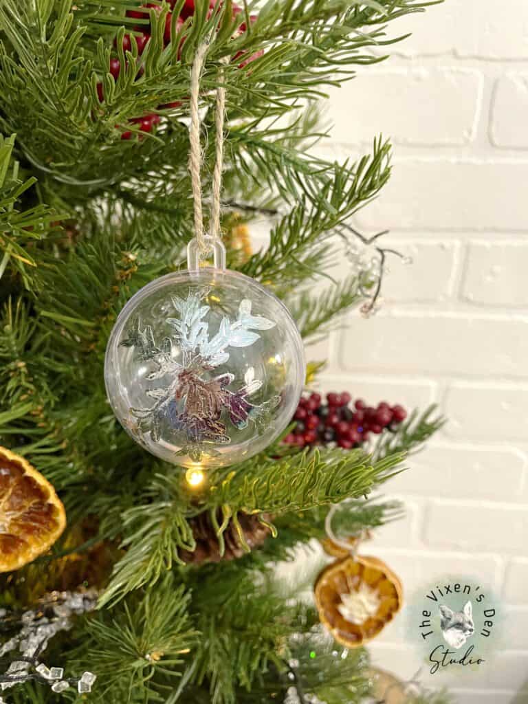 A glass ornament hanging on a christmas tree.