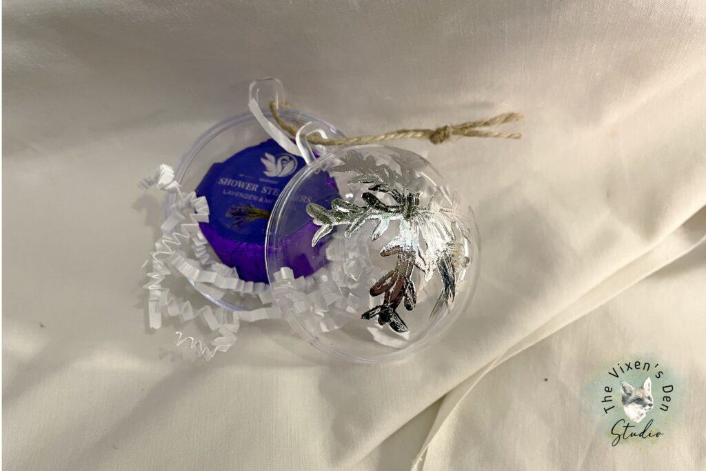 A clear plastic ornament with a flower on it.