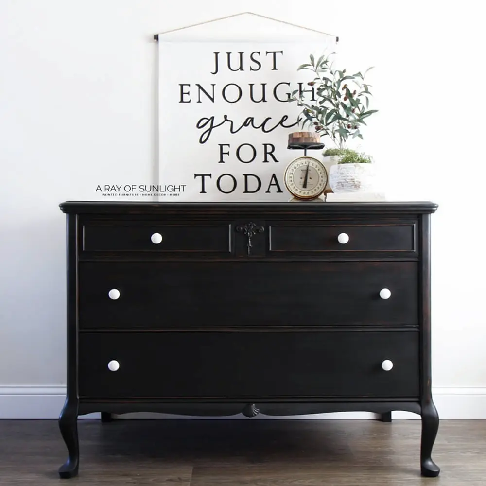 A black dresser with a sign that says just enough grace for today.