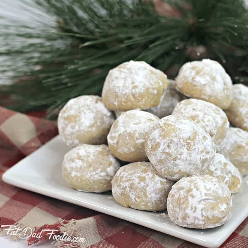 Powdered sugar cookies on a white plate.
