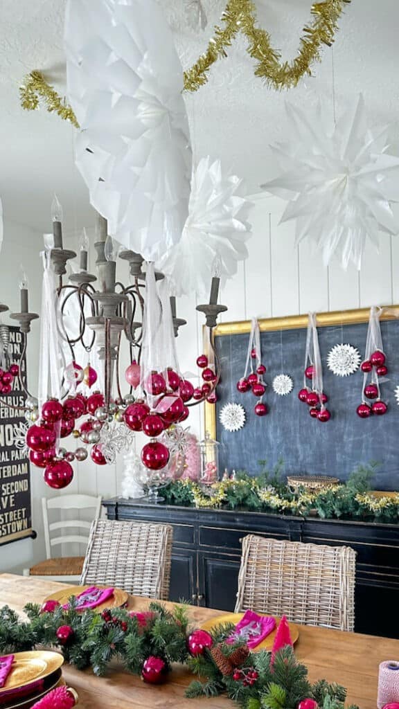 A dining room with christmas decorations and a chandelier.