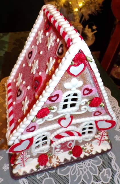 A gingerbread house decorated with red and white hearts.