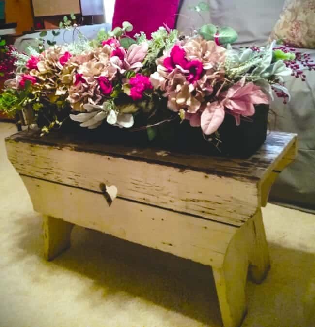 A wooden table with flowers on it.