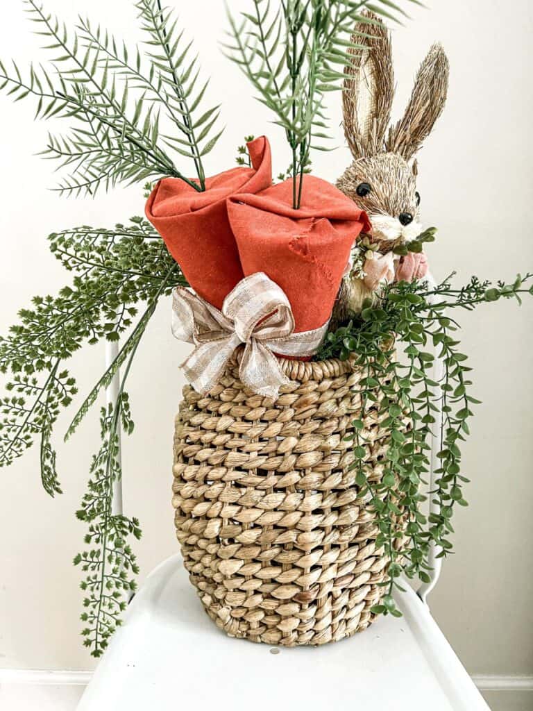 A wicker basket filled with flowers and a bunny.