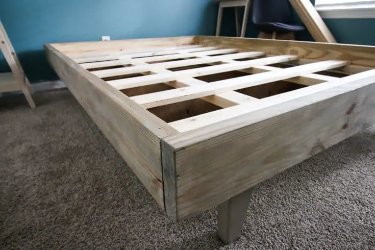 A bed frame that is being built in a room.