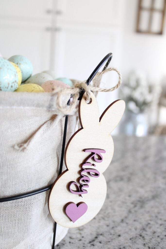 A basket of easter eggs with a wooden bunny tag.