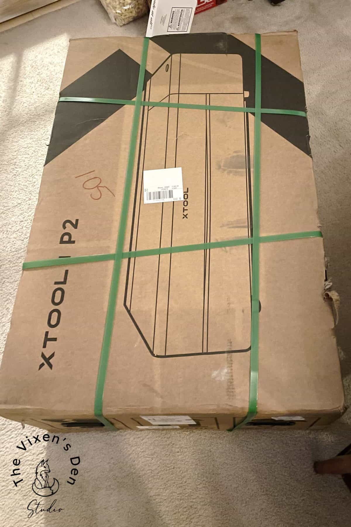 A box is sitting on a floor in a living room.