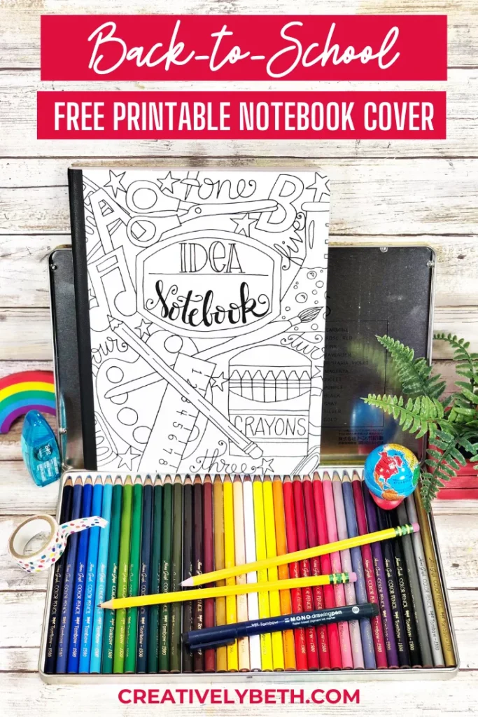 Colorful pencils arranged around a blank, black-and-white design notebook cover with "Back-to-School Free Printable Notebook Cover" text at the top and "creativelybeth.com" at the bottom.