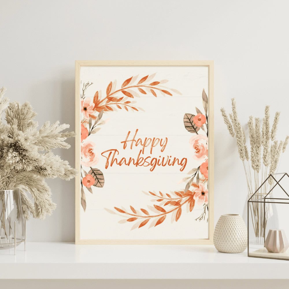 Framed "Happy Thanksgiving" sign with floral design, surrounded by decorative dried plants on a shelf.