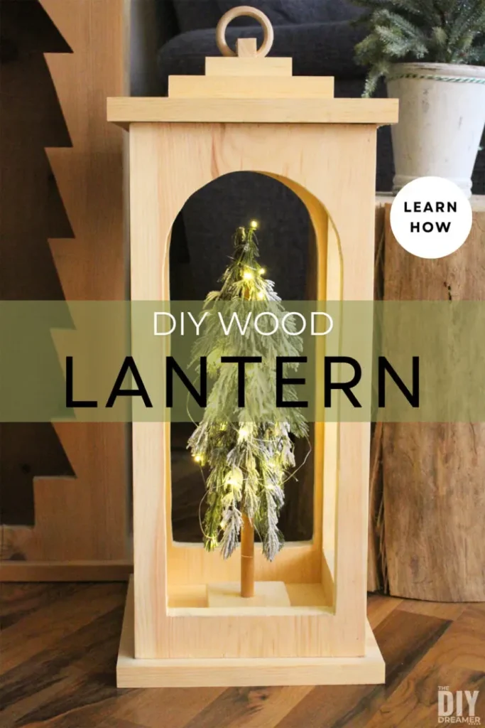 Wooden lantern with a small, illuminated Christmas tree inside. Text overlay reads "DIY Wood Lantern.