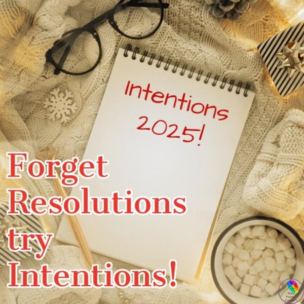 Notebook titled "Intentions 2025" surrounded by glasses, a pencil, and a cozy setting. Text reads: "Forget Resolutions, try Intentions!.