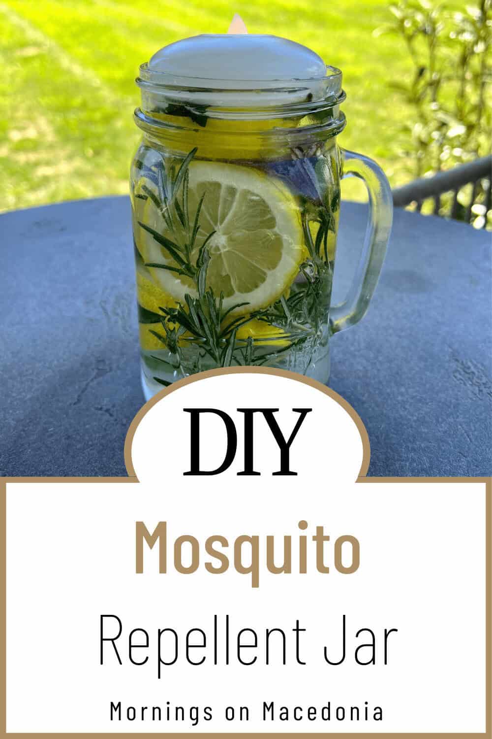 A mason jar filled with lemon slices, rosemary, and a floating candle, labeled as a DIY mosquito repellent jar on a table outdoors.