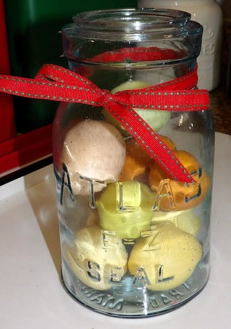 A clear glass jar labeled "Atlas E-Z Seal" contains several colored balls of dough and is tied with a red ribbon.