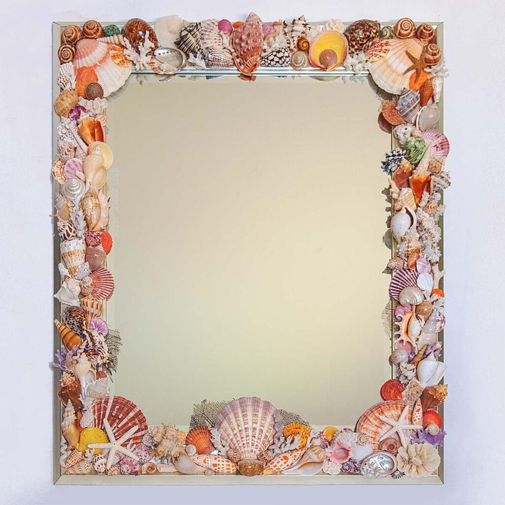 A rectangular mirror with a frame decorated with various colorful seashells and small starfish.