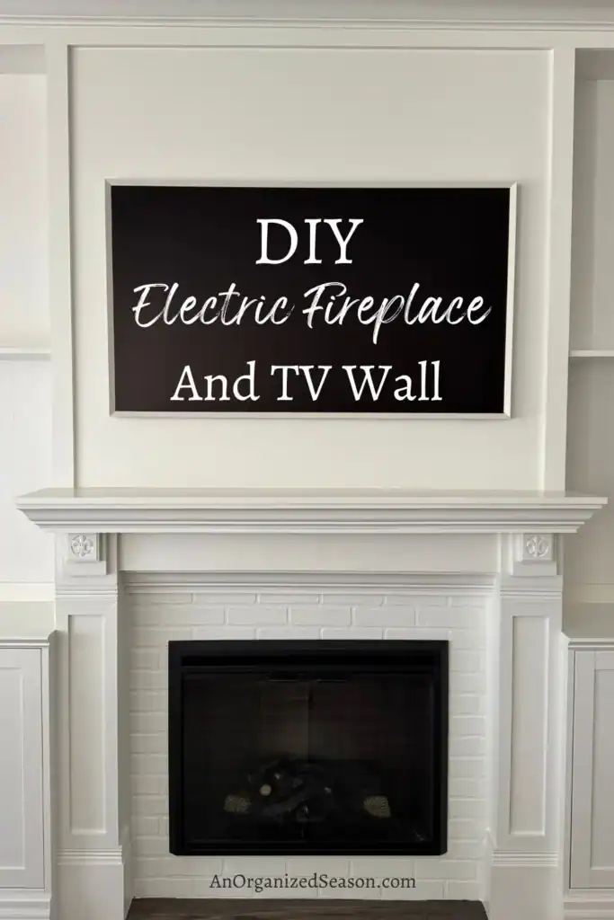 A white mantel and electric fireplace are built into a wall, with a large black sign above reading "DIY Electric Fireplace And TV Wall.